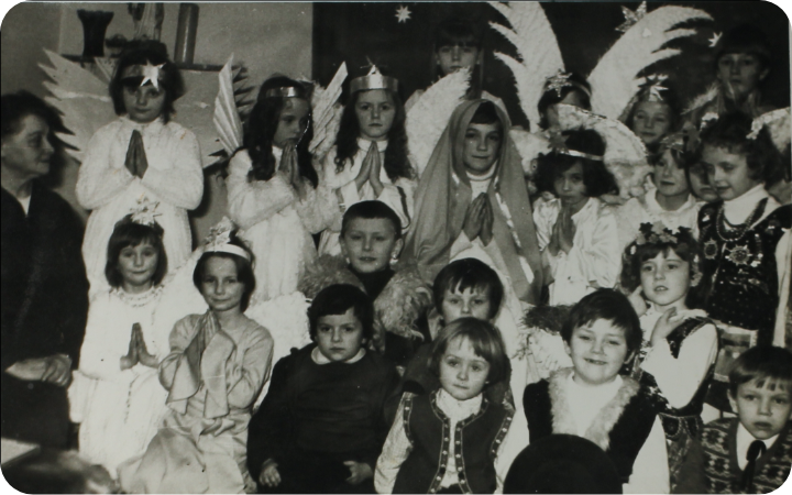 Grupa dzieci w przebraniach aniołów, pasterzy i strojach ludowych
